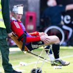 Aberdeen's Jack MacKenzie receives treatment after being hit with an object from the crowd