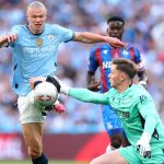 Dean Henderson handles the ball outside of his box to deny Erling Haaland