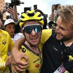 Simon Yates is hugged by a member of the Visma-Lease A Bike team staff after taking the lead in the 2025 Giro d'Italia