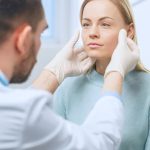 Plastic / Cosmetic Surgeon Examines Beautiful Woman's Face, Touches it with Gloved Hands, Inspecting Healed Face after Plastic Surgery with Amazing Results.