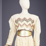 An ivory silk evening dress with embroidered detailing and gold belt by Karl Lagerfeld for Chloé, circa 1980, being auctioned at Bonhams Cornette de Saint Cyr.