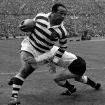 Legendary rugby league star Billy Boston (Wigan) bursts through despite a tackle by I. Watts (Hull) during the Rugby League Challenge Cup Fi