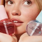 Model holding two Mane hair and body mists