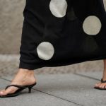 a woman wears a pair of heeled flip-flops