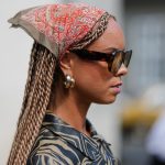 a woman wearing two hoop earrings and a silk scarf during copenhagen fashion week