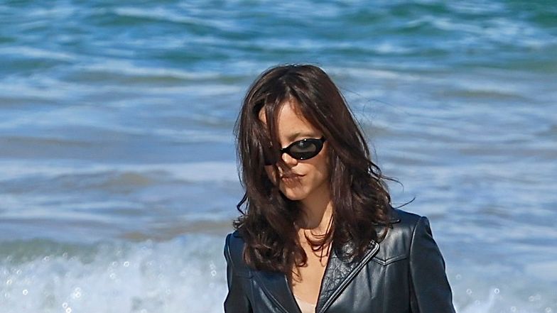 In a Leather Trench and Boots in Hand, Jenna Ortega Takes Beach Goth Style to the Extreme