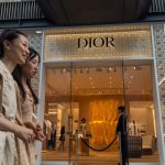 Chinese shoppers walk past a Dior store in Chengdu.