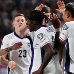 Noni Madueke is joined in celebration by his England team-mates