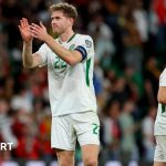 Republic of Ireland captain Nathan Collins claps to the Republic of Ireland support after their 1-0 defeat to Portugal in Lisbon, behind Collins, Jason Molumby walks away.