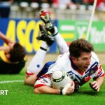 Shaun Edwards looks to the referee as a group of Australia players gather, with Bradley Clyde flat out on the ground