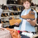 Teenage boy shopping for boots
